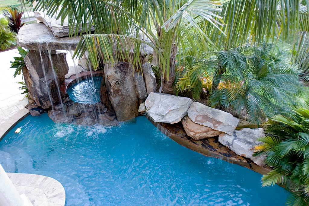 Lagoon pool with spa underneath natural Tennessee Fieldstone grotto waterfall, Siesta Key, Florida designed and built by Lucas Lagoons Inc.